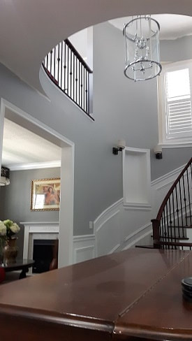 Spiral staircase with high vaulted foyer painted in a grey tone